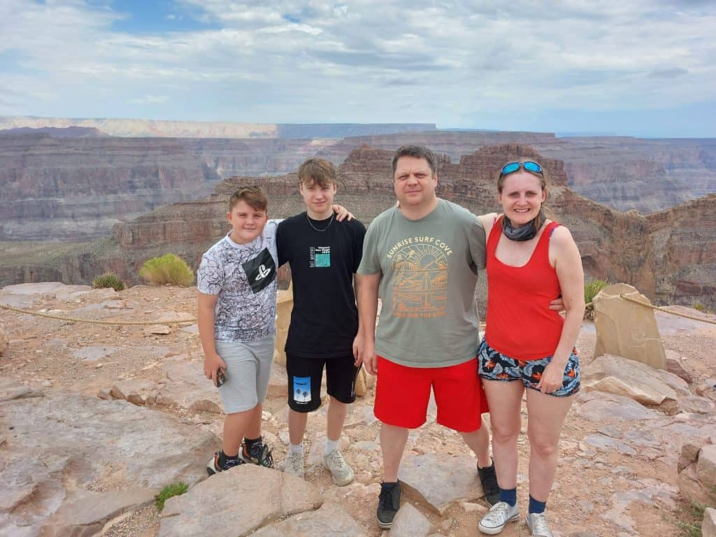 Gareth standing with his two sons and wife on a hike