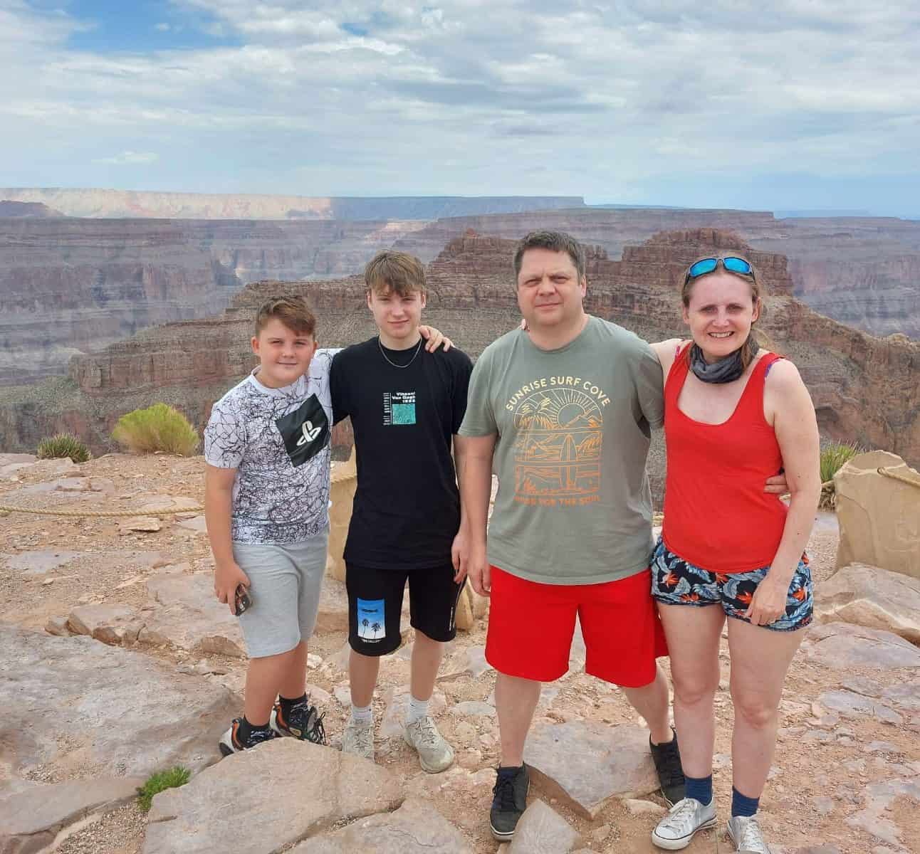 Gareth standing with his two sons and wife on a hike