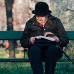 Lady reading a book on a bench