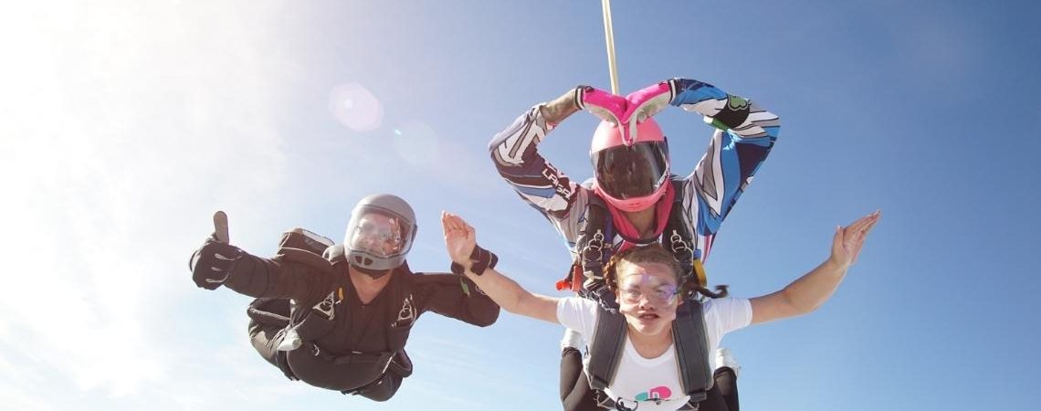 A trio of skydivers free fall in the sky
