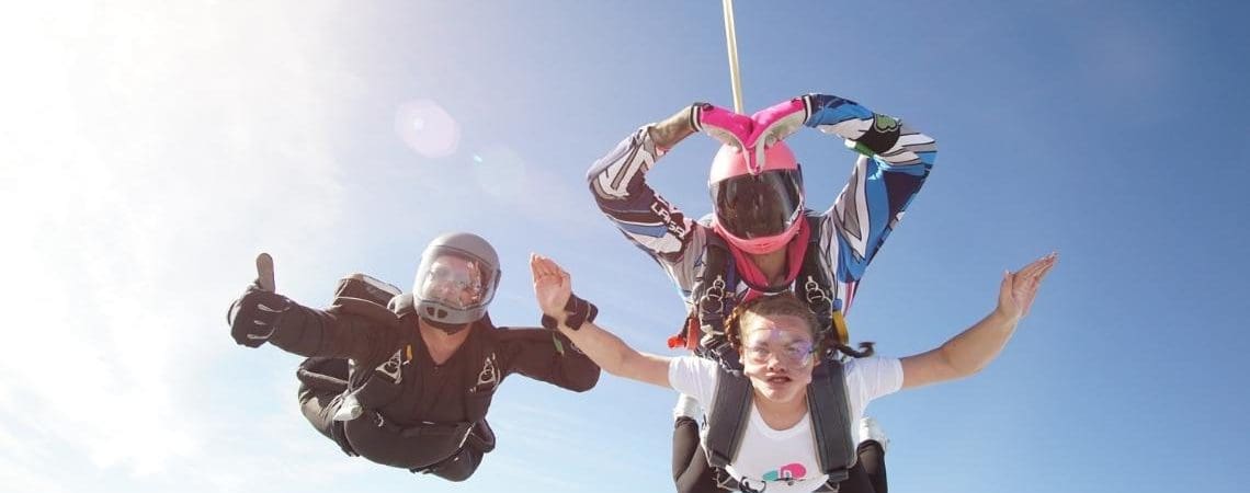 A trio of skydivers free fall in the sky