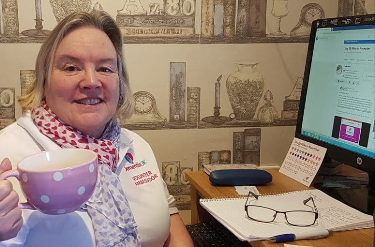 A volunteer holds a mug up in celebration