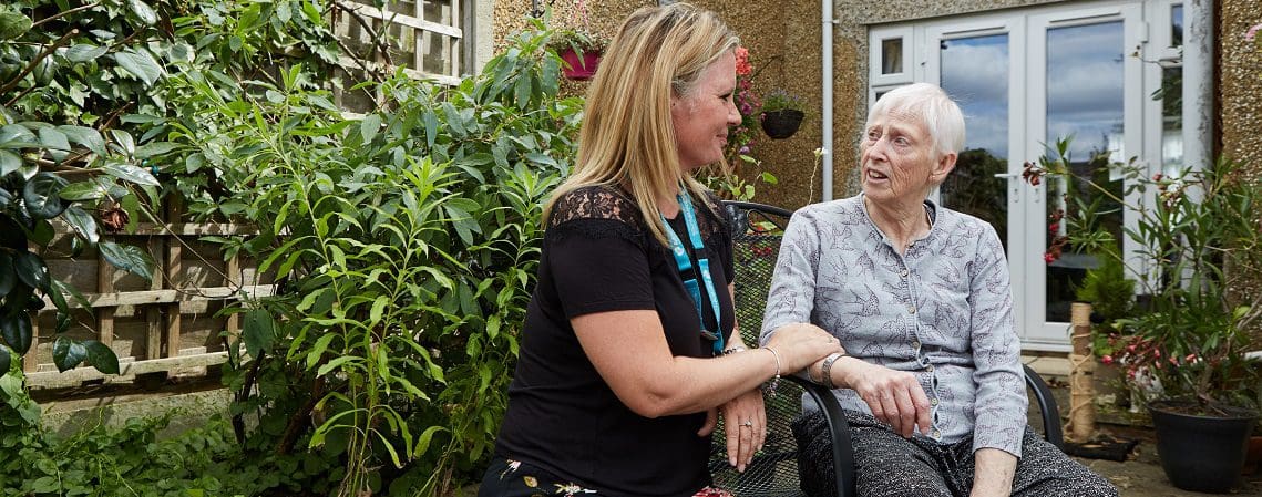 An admiral nurse talks to an older woman