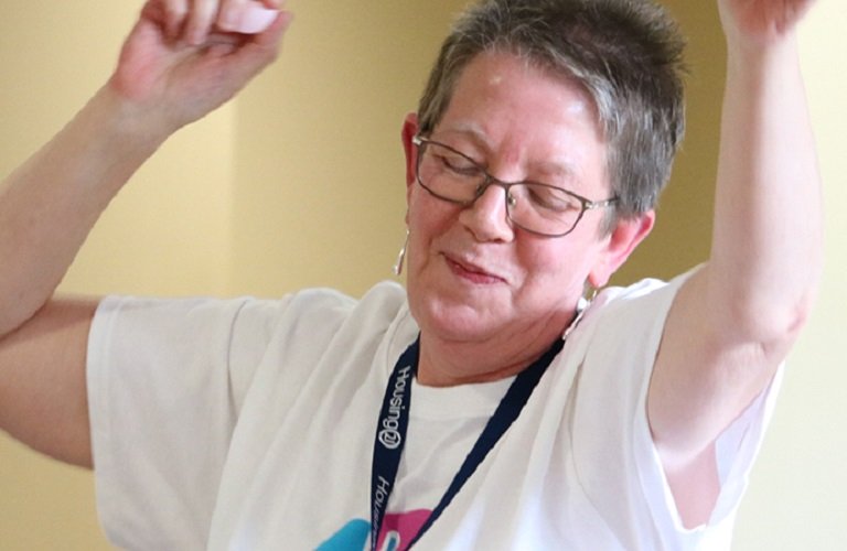 A woman dancing, wearing a Dementia UK T shirt