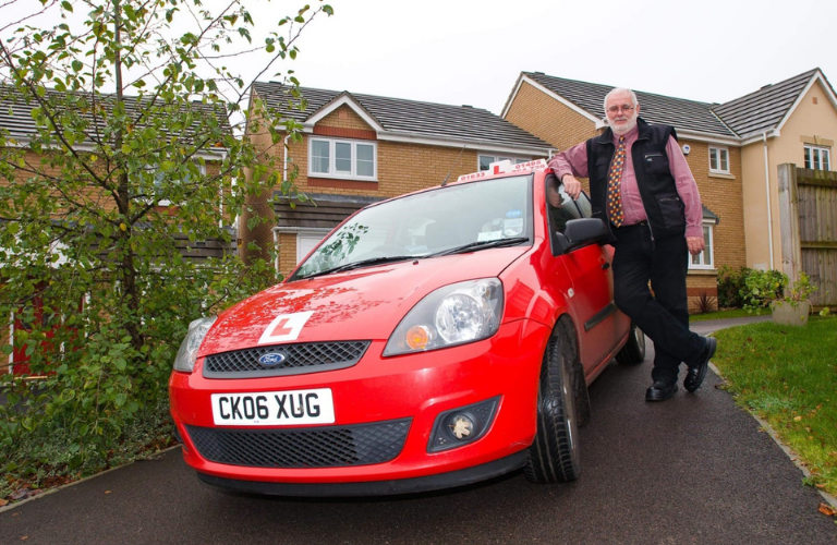 Angharad's father, next to a red car