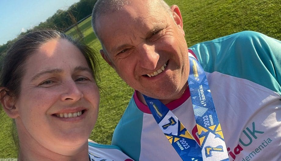 Woman and man standing together taking a selfie wearing dementia uk t-shirts and medals