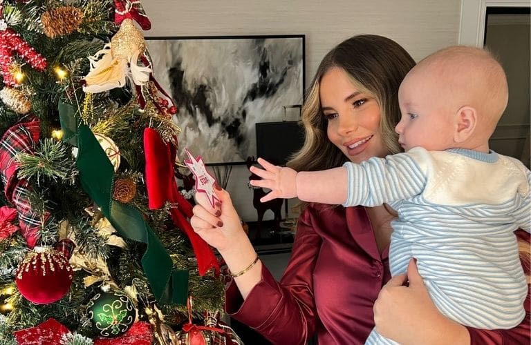 Georgia Kousoulou adding a star to her Christmas tree with baby son