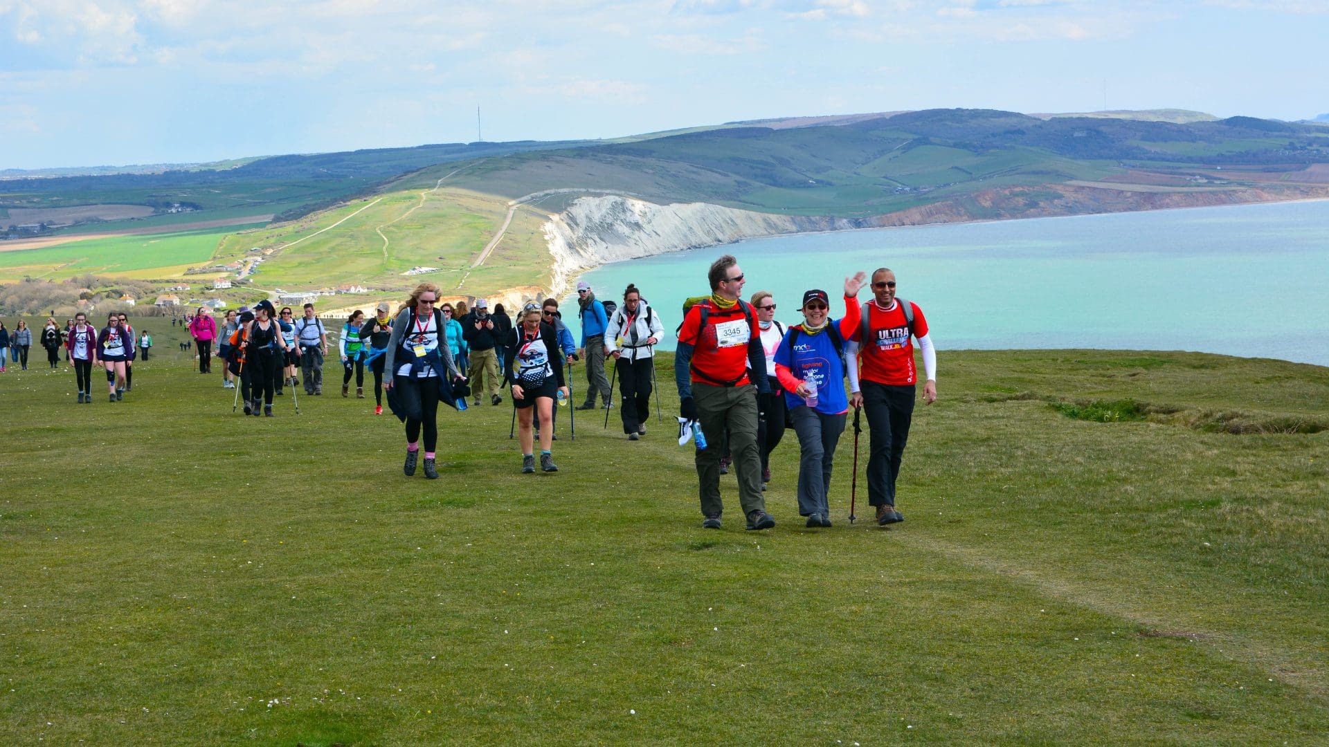 Large crowd of people walking along the Isle of Wight coastline