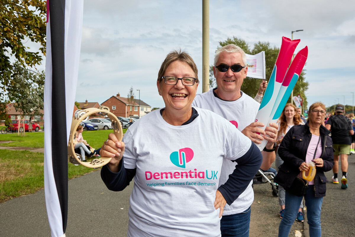 Runners at the Great North Run smile for a photograph. They wear Dementia UK T-shirts.