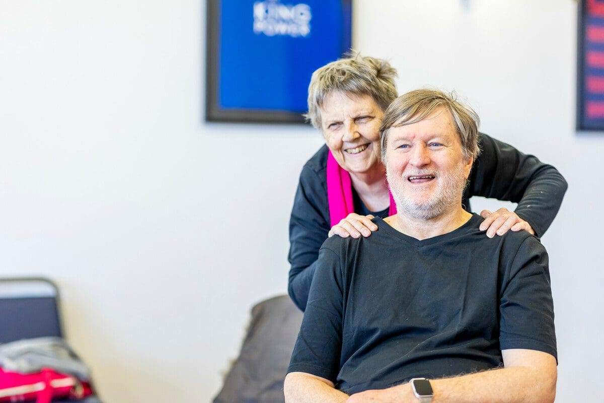 A man and woman smile together.