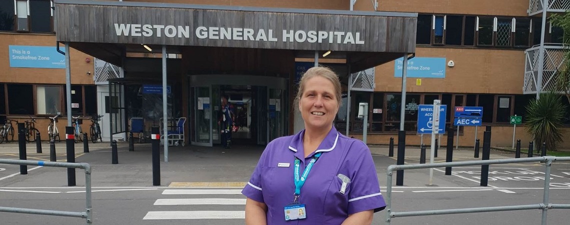 Admiral Nurse Sarah Oakwood standing in front of the hospital entrance