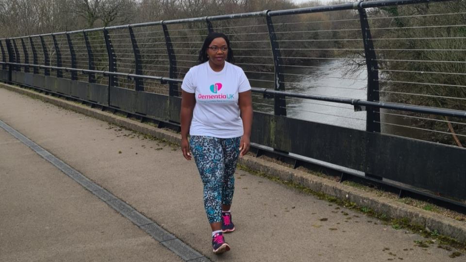 lady walking across a bridge wearing a Dementia UK branded tee shirt