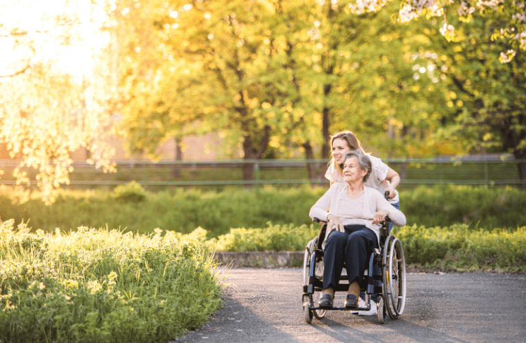 Mother in wheelchair and daughter pushing her outside