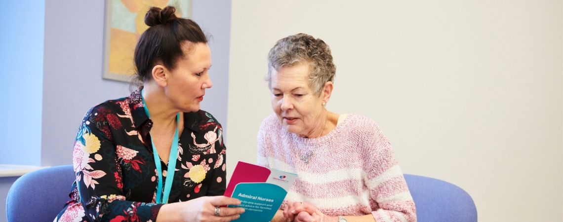 An Admiral Nurse shares a leaflet with an older woman