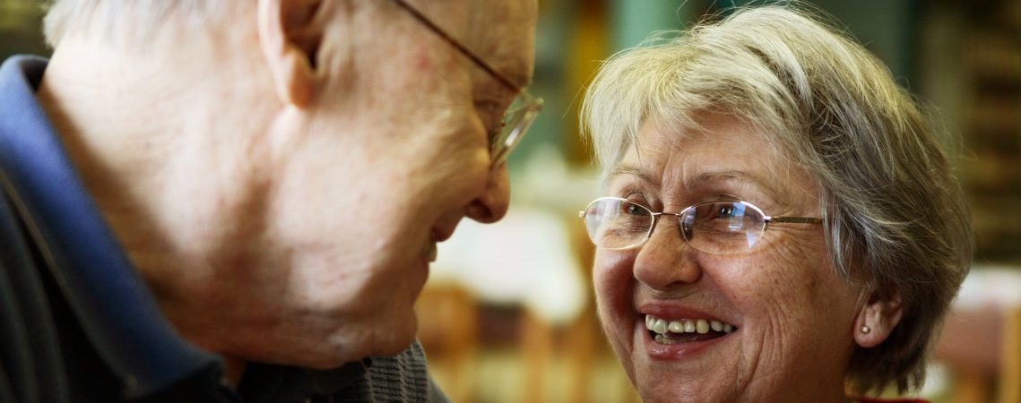 An older couple share a romantic glance