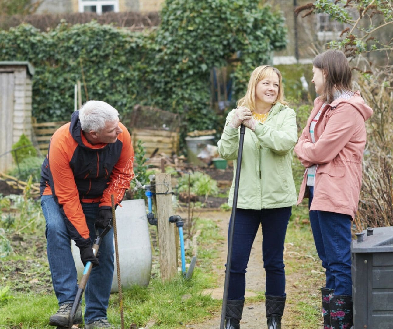 family of a dad, mum and daughter doing gardening