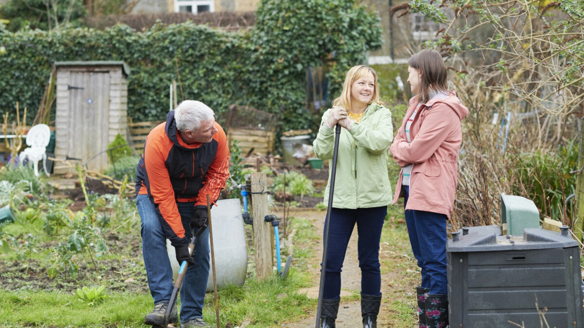 family of a dad, mum and daughter doing gardening